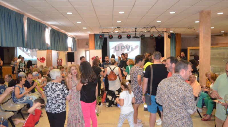 Unión del Pueblo Viseño (UPVI) organizó en la tarde del viernes un acto para acercar a sus candidatos a los viseños y viseñas, un acto que podríamos llamar de presentación de candidatura pero que, como en su intervención ante los asistentes dijo su candidata a la alcaldía, María Jiménez Campiñez, “esto no es una presentación al uso, donde la gente se sentaba a escuchar a los políticos sino un momento para compartir, para conocerse, acercarse y escuchar a nuestros vecinos y vecinas que ya que durante la campaña electoral habrá tiempo de política y programa”. Y así fue el acto, un cordial intercambio de impresiones, con un cortador de jamón preparando platos para ser degustados acompañados de un vino español, la intervención de la candidata sobre el escenario junto a su número 2, Arancha González para dar paso a un video de presentación de la candidatura y a su finalización, la foto de familia del equipo que aspira a regir los destinos de su pueblo durante la próxima legislatura.